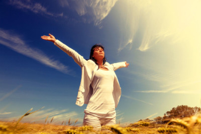 Woman with arms out in bliss at spiritual retreat