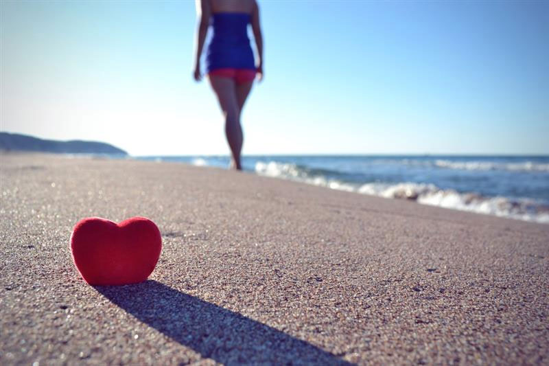 A small red heart on a sandy beach