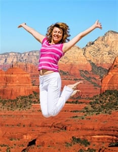 Woman jumping up in Sedona with arms spread open-Family Retreat