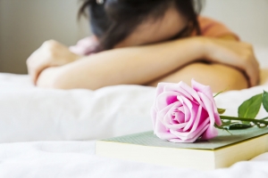 Woman Grieving Next to a Rose 