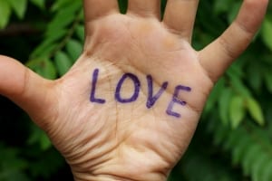The palm of a hand with the word LOVE written on it-Wellness Retreat