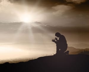 Man praying on a mountain top-Mens Retreats 