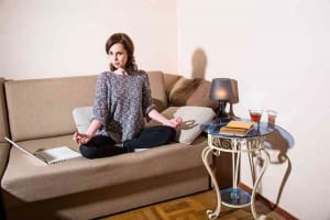 Woman meditating on a couch-