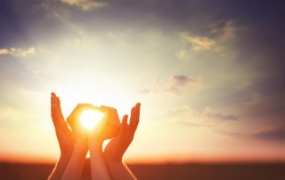 Adult hands cupping child's hands with sun shining through the child's hands-Family Retreat