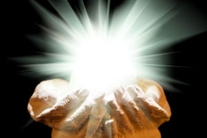Bright ball of light resting on the palm of 2 hands