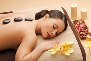 Woman resting with smooth black rock on her back-Spa Sedona Retreat Vacation