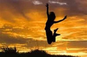 Woman jumping up with joy at sunset