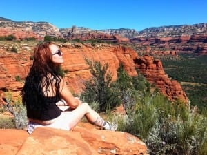 A woman practicing mindfulness on the red rocks during a Sedona Vortex Journey for spiritual healing