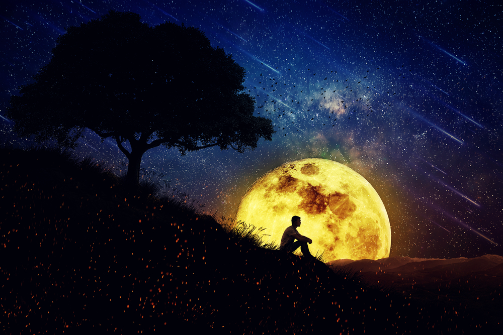 Man sitting in front of moon at night. Fresh Eyes.