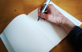 Hand journaling self-care on a page,