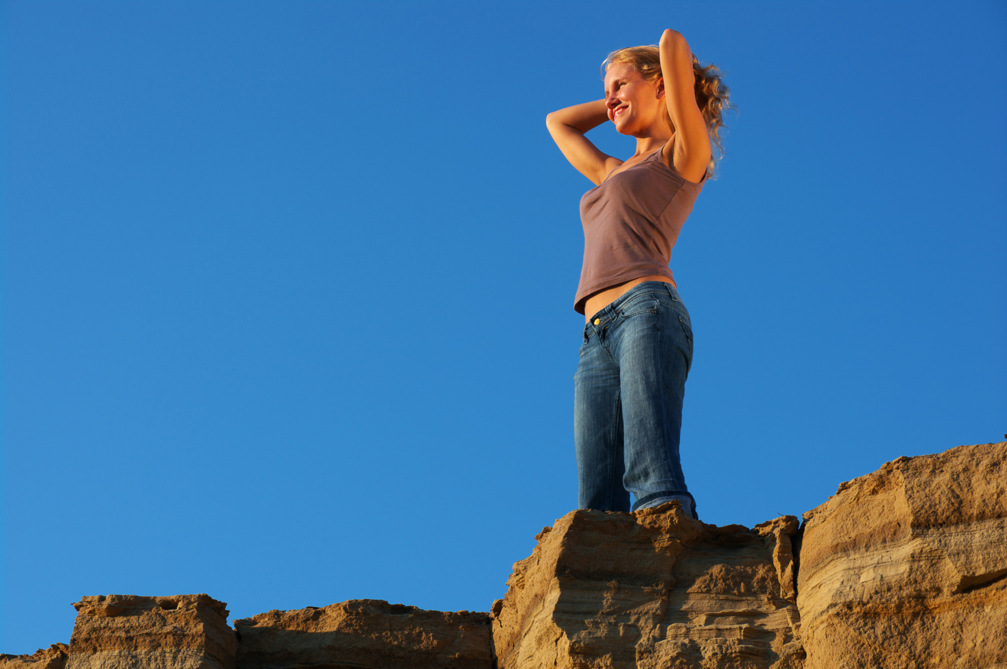 Young woman standing on rock formation-Wellness Retreat
