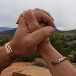 Couple holding hands with Sedona nature in the background