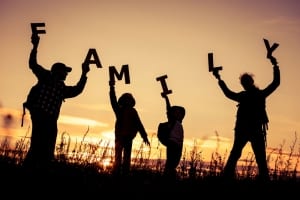 A family of 4 holding letters that spell out FAMILY-SpiritQuest