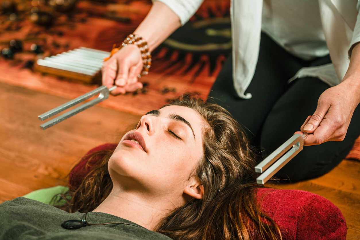 Woman laying down during a tuning fork sound therapy session