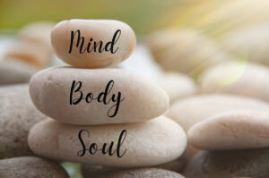 Light shining on zen stones with words Mind, Body, Soul on blurred background. Customize space for text or ideas river rocks mind body soul sedona
