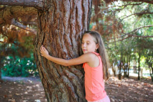 Girl hugging tree in park. healing inner child session