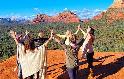 women joining hands on vortex in sedona before heading back to the retreat center