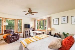 Cozy sitting area and queen bed in the Owl Wisdom private retreat room at SpiritQuest Sedona.