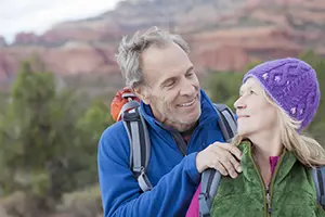 A happy couple smiling and embracing outdoors during a couples group retreat in Sedona, Arizona.