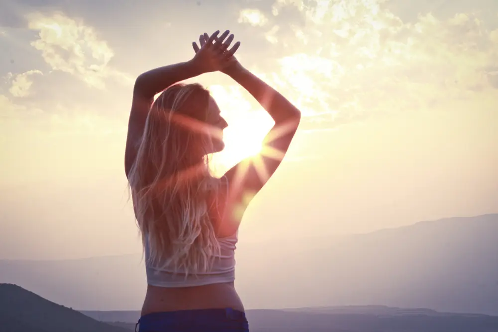 A workshop participant practicing mindfulness and self-awareness outdoors in the sun.