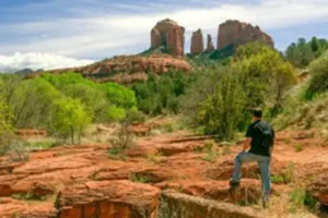 An individual participating in a private outdoor shamanic ceremony and land journey on the Sedona red rocks.