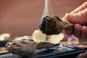 A burning sage bundle used for a sacred spiritual clearing and shamanic ceremony during a Sedona retreat.
