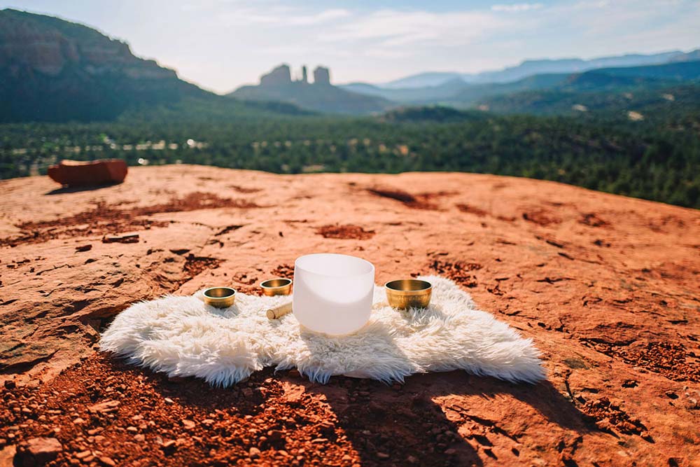 Himalayan-bowls-healing-retreat-packages (2) crystal bowls on red rocks during a spiritual group retreat session