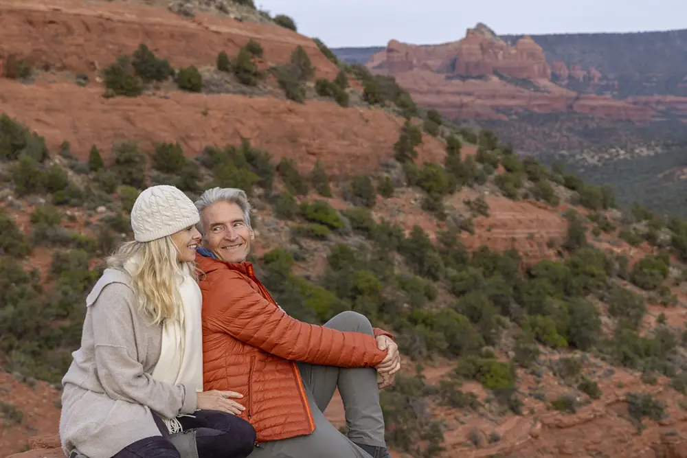 red-rock-commitment-with-spiritquest couple sits close on a red rock platform during a spiritquest couples retreat